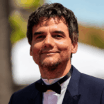 Après plusieurs années consacrées au cinéma et aux séries, Wagner Moura signe un retour remarqué au théâtre. L'acteur brésilien, connu dans le monde entier pour son rôle de Pablo Escobar dans Narcos, est à l'affiche de Un procès – après l'ennemi du peuple, présenté au Gymnase du lycée Aubanel dans le cadre du Festival d'Avignon 2026. Le spectacle est mis en scène par Christiane Jatahy, avec qui il collabore depuis longtemps. Ensemble, ils proposent une nouvelle lecture de Un ennemi du peuple, la célèbre pièce d'Henrik Ibsen publiée en 1882. Plutôt qu'une adaptation fidèle, ils imaginent ce qui pourrait arriver après les événements du texte original.